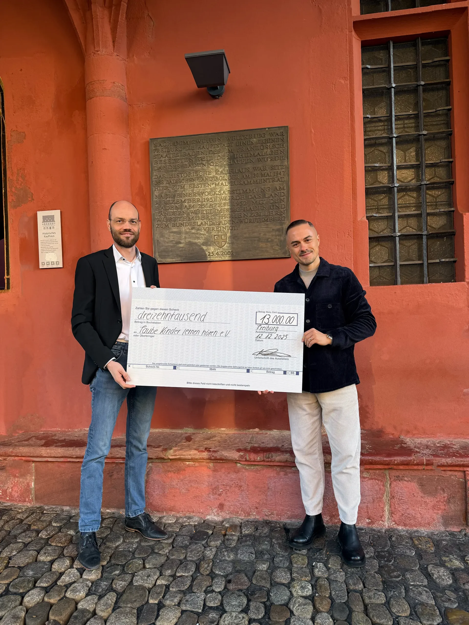 Scheckübergabe über 13.000 Euro aus einer Jubiläumsverlosung zugunsten des Vereins „Taube Kinder lernen hören“ mit Dr. Ingo Reinke.